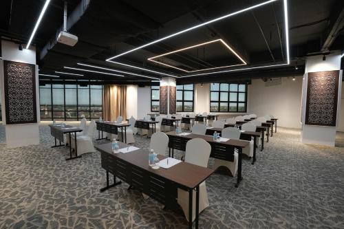 a dining room with tables and chairs and windows at Renai Hotel Kota Bharu in Kota Bharu