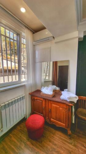 a room with a wooden desk and a red chair at Apple Hotel in Yerevan