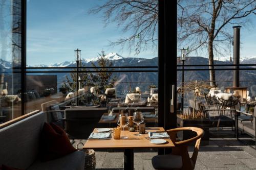 a table on a balcony with a view of the mountains at Miramonti Boutique Hotel in Avelengo