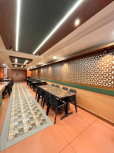 a restaurant with tables and chairs in a room at City Palace Hotel in Ooty