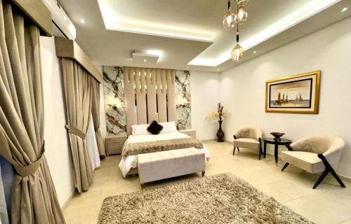 a bedroom with a bed and a couch and chairs at Grand Berkshire Signature Hotel operated by Berkshire Hotels & Resorts UK in Islamabad