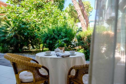 einen Tisch mit einem weißen Tischtuch und zwei Tassen in der Unterkunft Hotel Bristol in Bellaria-Igea Marina