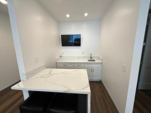 eine weiße Küche mit einem Tisch und einem Waschbecken in der Unterkunft Bear Port Cabin Getaway in Big Bear City Airport