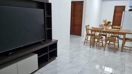 a living room with a television and a table with chairs at Perla Sibauma in Tibau do Sul