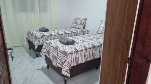 two twin beds in a room with a door at Perla Sibauma in Tibau do Sul