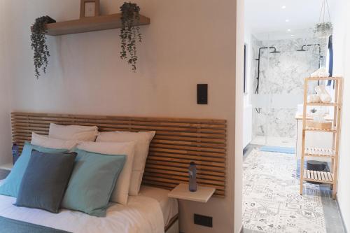 Schlafzimmer mit einem Bett mit weißen und blauen Kissen in der Unterkunft Green Suite & Spa in Mons