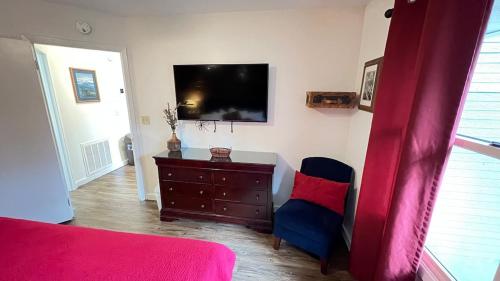 a bedroom with a bed and a dresser and a flat screen tv at Cub Way-Cozy 1 bedroom with sleeping loft in Gatlinburg
