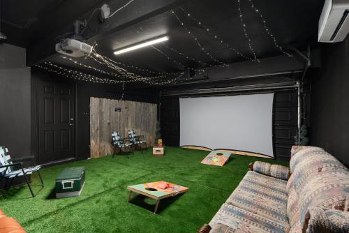 a living room with a couch and a white screen at Pool Getaway Movie Room Games Yard Bbq Pets in Round Rock