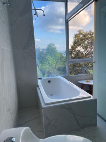 a bathroom with a tub and a sink and a window at Luxury85 Blue in Bucaramanga