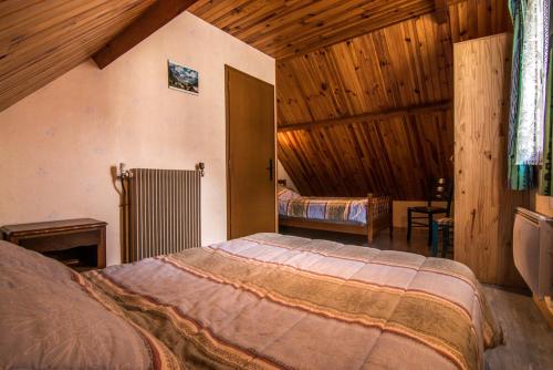 ein Schlafzimmer mit einem Bett in einem Zimmer mit Holzwänden in der Unterkunft La Biasou in Gèdre