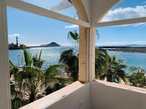 a room with a window looking out at the water at La Manga Caralmar Paraíso in La Manga del Mar Menor