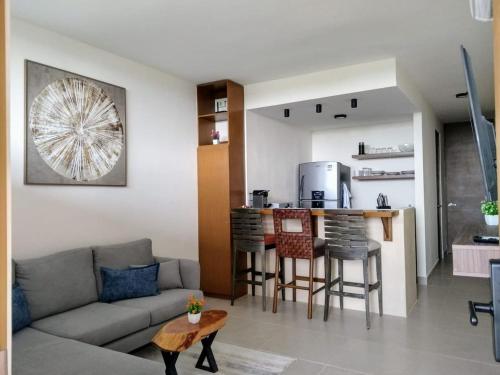 a living room with a couch and a bar at Encanto de Montebello in Mérida