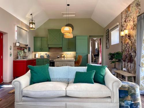 a living room with a white couch and green cabinets at Summerhill Byre in Ballymena