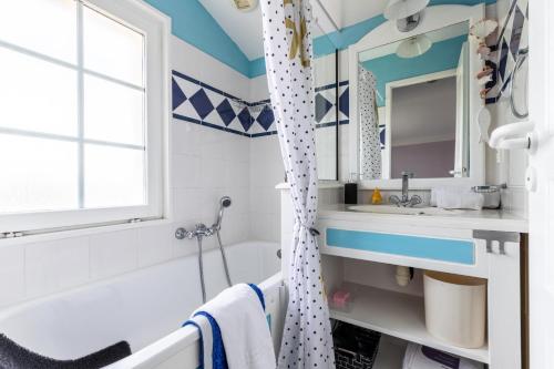 une salle de bain avec une baignoire, un lavabo et un miroir dans l'établissement Les Maisons de Port Bourgenay - maeva Home - Maison climatisée 3 pièces 6 personnes - Prestige MAE-7481, à Saint-Hilaire-de-Talmont