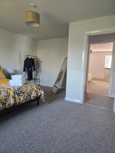 a bedroom with a bed and a hallway at Benji & Milo's Farmhouse in Hillhead
