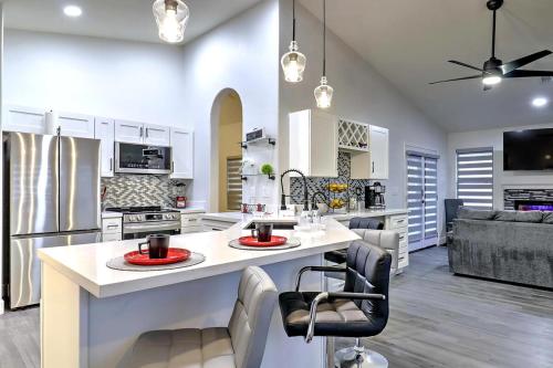 a kitchen and living room with a large island with chairs at Executive Retreat near State Farm Stadium in Glendale
