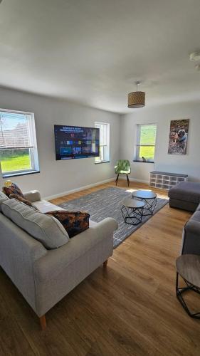 a living room with a couch and a tv at Benji & Milo's Farmhouse in Hillhead