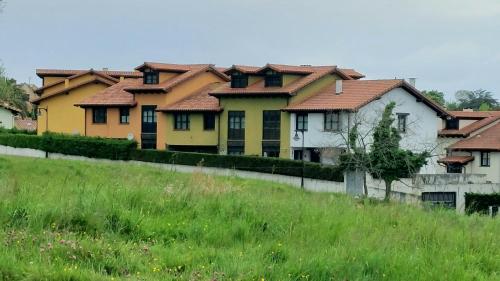 a row of houses with a green field in front at Duplex Colombres in Colombres