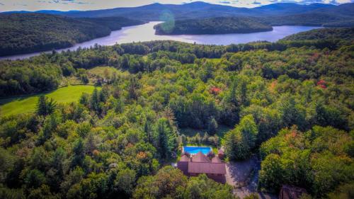 an aerial view of a house in the woods next to a river at Most Luxury 7000 Sq ft Log Estate with Pool Hot Tub Sauna in Wilmington