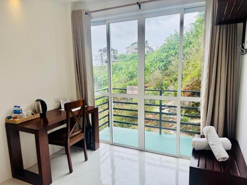 a room with a desk and a window with a view at Queens Mount Glen Heights in Nuwara Eliya
