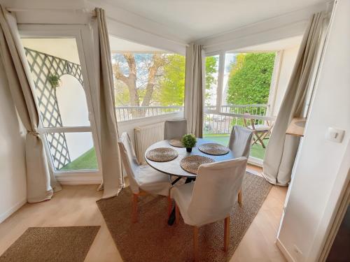 une salle à manger avec une table et des chaises et un balcon dans l'établissement Appartement à 10 minutes à pied du centre ville avec parking privé et balcon, à Caen