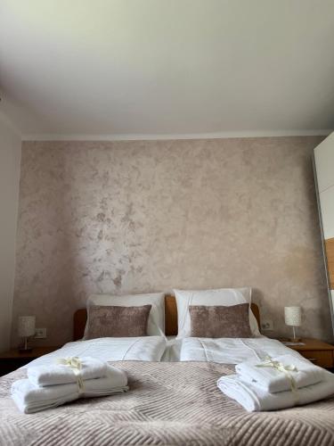 two beds with towels on them in a bedroom at Mala Oaza Apartment in Sarajevo