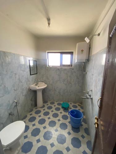 a bathroom with a toilet and a sink at NH1 Hotel and Restaurant in Kargil