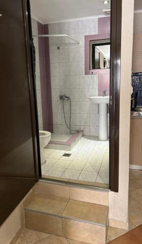 a bathroom with a shower and a toilet and a sink at Del Mar in Nea Vrasna
