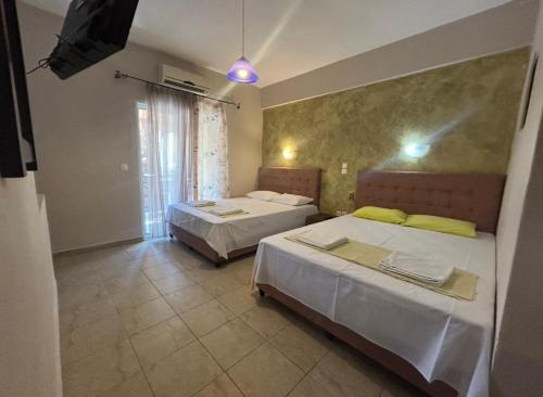 a bedroom with two beds and a tv in it at Del Mar in Nea Vrasna