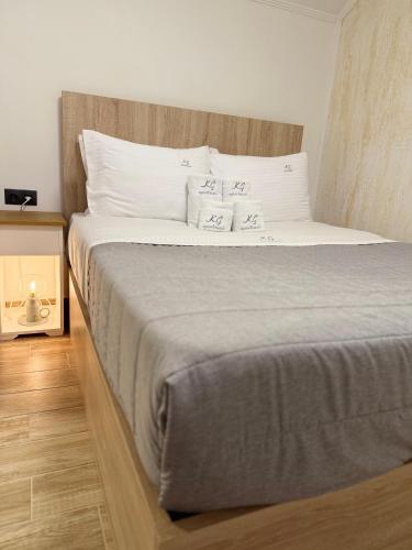 a large bed with white sheets and pillows at K.G APARTMENT 2 in Pefkohori