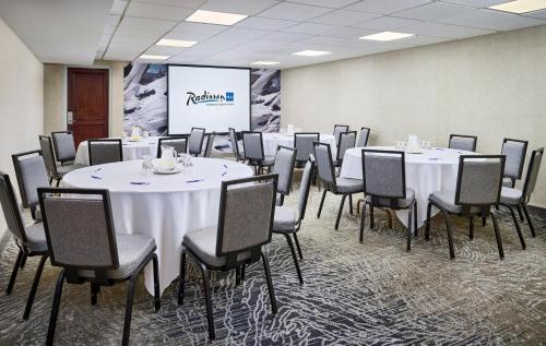 a conference room with tables and chairs and a screen at Radisson Blu Toronto Downtown in Toronto