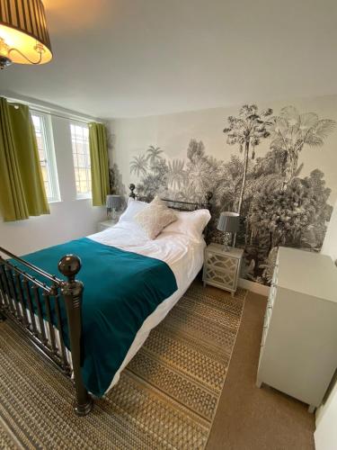 a bedroom with a large bed with a blue blanket at Gallery Apartment in Stratford-upon-Avon