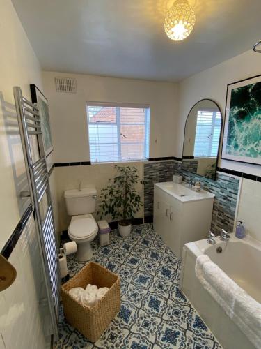 a bathroom with a toilet and a sink and a tub at Gallery Apartment in Stratford-upon-Avon