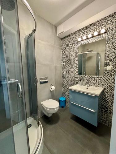 a bathroom with a toilet and a sink and a shower at Apartament Kamionka Piast in Opole