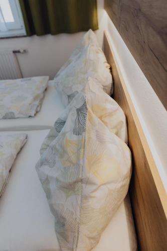 a bed with two pillows in a box at Pension Kinzl mit E-Ladestation in Offenhausen
