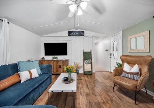 ein Wohnzimmer mit einem blauen Sofa und einem Fernseher in der Unterkunft Hot Tub, Fire pit & Pet-friendly Riverside Retreat in New Braunfels