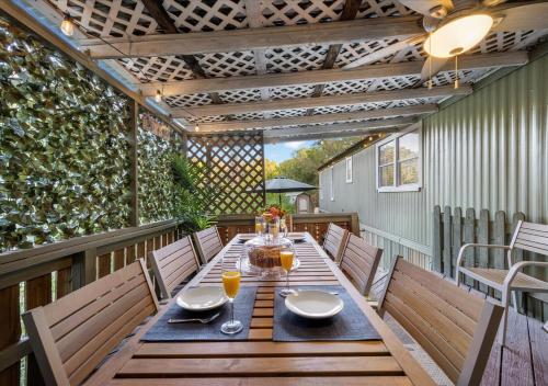 einen Esstisch im Freien mit Stühlen auf einer Terrasse in der Unterkunft Hot Tub, Fire pit & Pet-friendly Riverside Retreat in New Braunfels