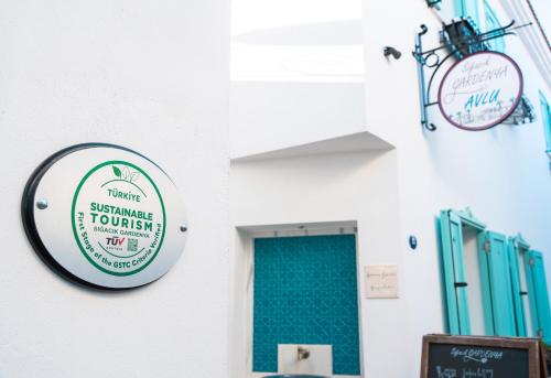 a sign for a restaurant on a wall with a door at Sigacik Gardenya Buti̇k Otel in Siğacık