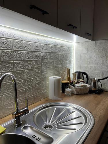 a kitchen sink with a faucet and a counter top at Unik's Studio Apartment in Prizren