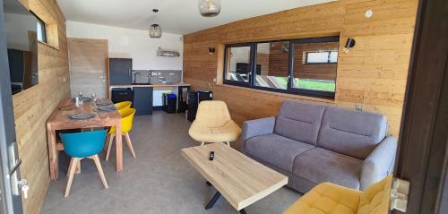 un salon avec un canapé et une table dans l'établissement Gîte les caisses en bois et SPA accès PMR -Oslo-, à Charmes