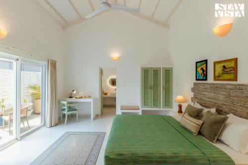 a bedroom with a large green bed in a room at StayVista at Villa Serenity with Private Pool, Wi-Fi in Mandrem