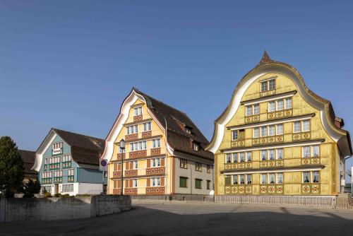 a large yellow building with two smaller buildings at Blattenheimat6 - im traditionellen Appenzeller Haus in Appenzell