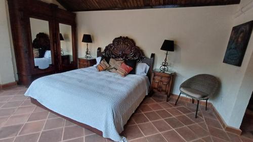 une chambre avec un grand lit et une chaise dans l'établissement Lovely Cottage at La Ropa Beach, à Zihuatanejo