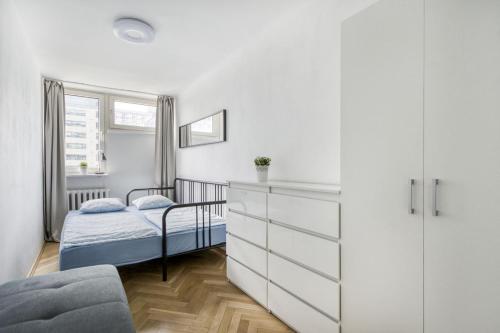 a small bedroom with a bed and a dresser at Śliska Residence in Warsaw