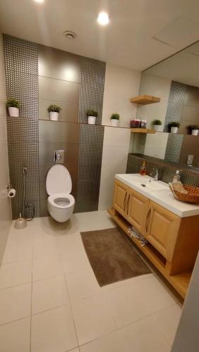 a bathroom with a toilet and a sink at قصر تل الرمان in Ar Rummān
