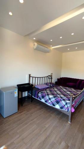 a bedroom with a bed and a desk in a room at قصر تل الرمان in Ar Rummān