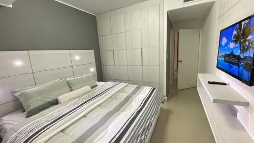 a bedroom with a large bed and a flat screen tv at Alquiler Apartamento Vacacional con Vista al Mar, Isla de Margarita in Porlamar