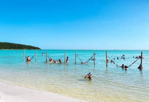 a group of people in the water at the beach at Loft 11, caminho do mirante in Iguaba Grande