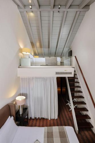 a room with a staircase with a bed and a stair case at Despotiko in Portariá