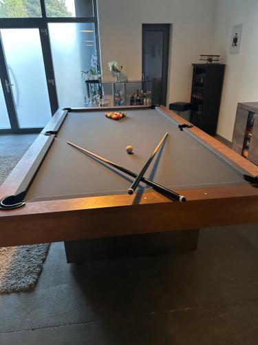 a pool table with two cue sticks on it at Bunker 35 in Kevelaer